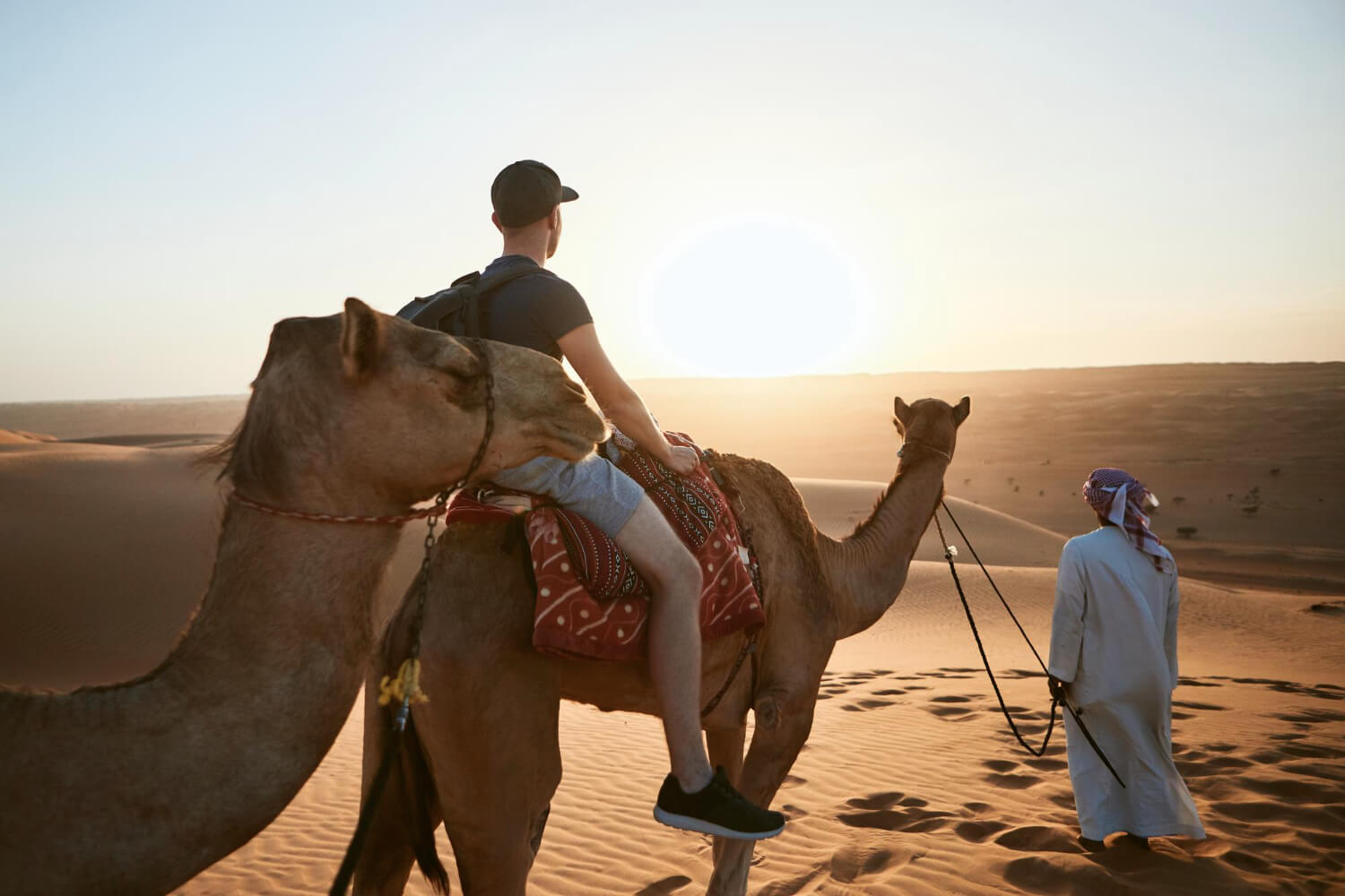 Homem andando no camelo no deserto