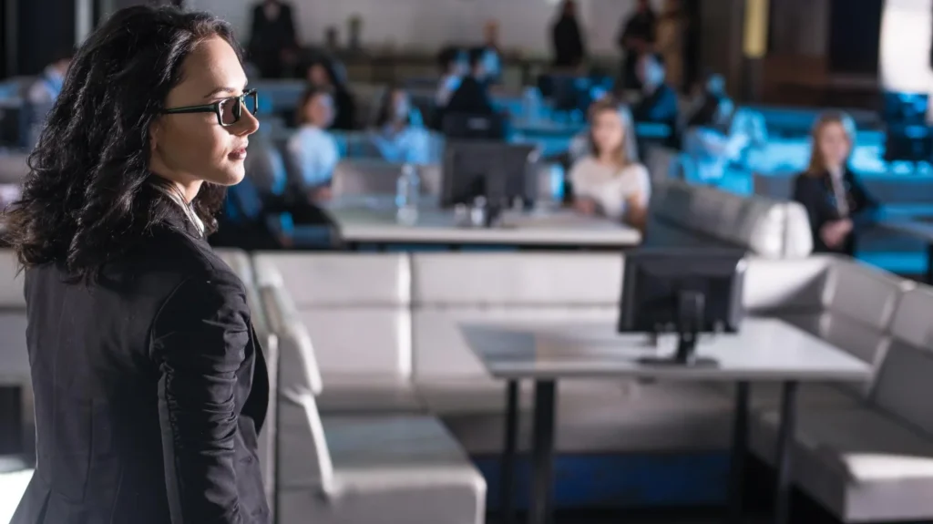 Palestrante feminina diante de plateia em evento corporativo